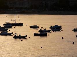 Backlighting of sport boats at anchor in a bay photo