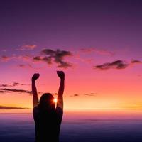 Silhouette of young woman at sunset on sea background. photo