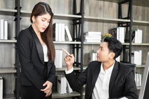 A male boss who pursues responsibility and a female businessman who receives power harassment. dissatisfied boss points on rude mistakes on report criticizing work scolding accusing  female employee photo
