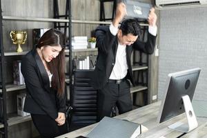 Emotional colleagues fighting in office. Workplace conflict. Angry boss. Man as a boss in the office is violent against a woman as an employee photo