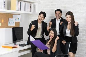 sí empresarios triunfando por el crecimiento financiero de la empresa. felices empresarios sonrientes triunfando con los puños levantados. foto