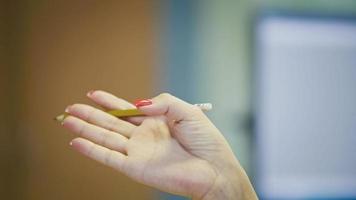 Hand gestures of Woman Office Manager when talking on the phone - manicure with bright red nails, close up photo