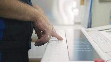 Industrial Worker. Man using control panel of the Printing machine. photo