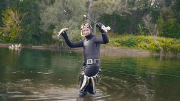 Spear fisherman shows Freshwater Fish at of underwater after hunting in forest river photo