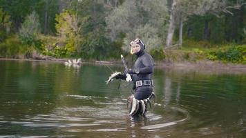 el pescador de lanza muestra peces de agua dulce después de cazar en el río del bosque foto