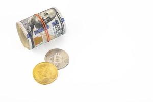 Gold and platinum bitcoins and a roll of US dollars on a white background. New virtual money. Copy space. photo