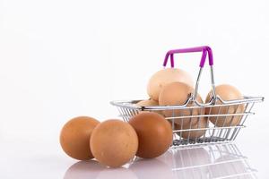 Beige, wild and farm chicken eggs in a shopper's basket on a white background. Selective focus. Copy space. photo