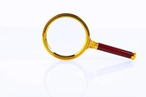 Magnifying glass in a gold frame on a white background. Research and education concept. Copy space. photo