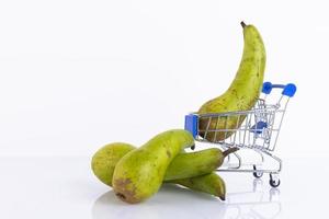 Green conference pears in a shopping cart, on a white background. Copy space. photo