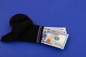 A money sock, a bundle of American hundred dollar bills hidden in a sock. Savings and storage concept. Copy space. photo