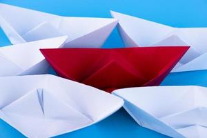 Red, white paper ship on a blue background. Leader concept. Copy space. photo