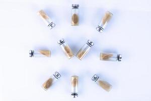 Vials, ampoules with a dry probiotic, bifidobacteria inside on a white background are laid out in the form of a clock. Copy space. photo