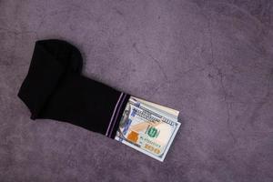 A money sock, a bundle of American hundred dollar bills hidden in a sock. Savings and storage concept. Copy space. photo