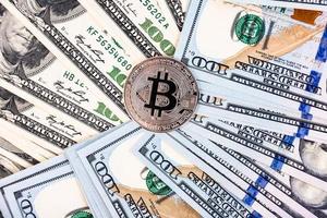 Platinum bitcoin on the background of one hundred dollar bills photo