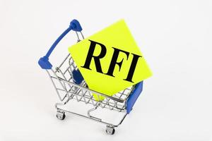 Shopping cart and text RFI Request for information on yellow paper note list. Shopping list, business concept on white background. Copy space photo