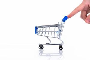 Female hand with fingers pushing a shopping cart isolated on white background. Copy space. photo
