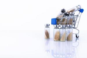 Vials, ampoules with dry probiotic, bifidobacteria inside, in the shopping cart. against the background of belrm. Copy space. photo