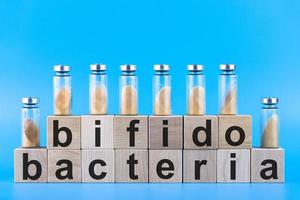 Vials, ampoules with dry probiotic, bifidobacteria, with probiotic powder inside on a blue background. Copy space. photo