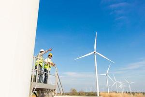 equipo de ingenieros trabajando en un parque de turbinas eólicas. energía renovable con generador de viento por concepto de energía alternativa. foto