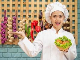 Asian woman in chef's uniform is cooking in the kitchen photo