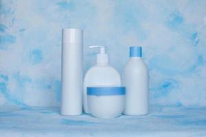 un conjunto de contenedores blancos de plástico. embalaje, plantilla de botella para cosméticos, antiséptico, con detergentes y limpiadores químicos, para productos médicos y cosméticos. fondo azul blanco foto