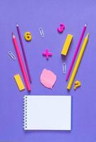 Back to school concept. School and office supplies on the office table. Violet background.Flat lay photo