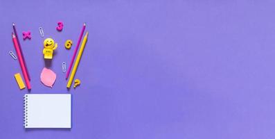 Back to school concept. School and office supplies on the office table. Violet background.Flat lay photo