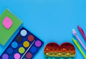 Back to school concept. School and office supplies on the office table and antistress toy. Flat lay photo