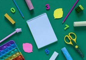 Back to school concept. School and office supplies on the office table and antistress toy. Flat lay photo