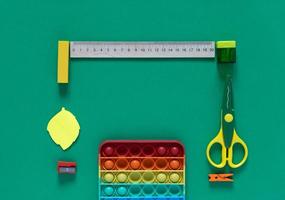 Back to school concept. School and office supplies on the office table and antistress toy. Flat lay photo