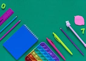 Back to school concept. School and office supplies on the office table and antistress toy. Flat lay photo