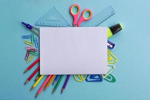 Top view of school supplies and office supplies on blue background. Learning, study, office equipment and presentation concept.