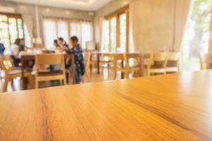 Restaurant interior with customer and wood table blur abstract background with bokeh light photo