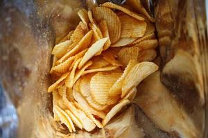 Potato chips in open snack bag close up photo