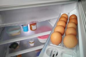 los huevos se organizan en el estante del refrigerador foto