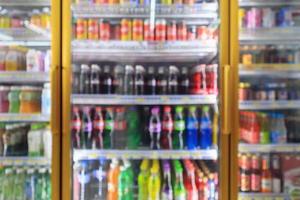 supermarket convenience store refrigerators with soft drink bottles on shelves abstract blur background photo