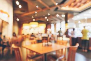 Restaurant interior with customer and wood table blur abstract background with bokeh light photo