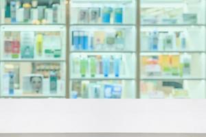 Pharmacy counter with medicines healthcare product arranged on shelves in drugstore blurred defocused background photo