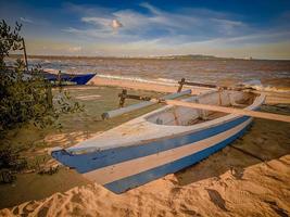 bote pequeño en la playa, utilizado como exhibición para un lugar para tomar fotografías por personas que viajan a la playa y no para ser utilizado en el agua foto