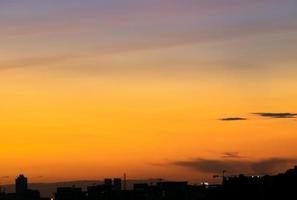 da una sensación cálida, la puesta de sol detrás del edificio de la ciudad, los edificios altos de la ciudad de la silueta, la silueta del edificio de nuevo el hermoso fondo del cielo y el concepto de libertad. foto