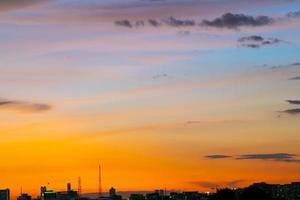 da una sensación cálida, la puesta de sol detrás del edificio de la ciudad, los edificios altos de la ciudad de la silueta, la silueta del edificio de nuevo el hermoso fondo del cielo y el concepto de libertad. foto