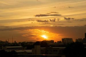 da una sensación cálida, la puesta de sol detrás del edificio de la ciudad, los edificios altos de la ciudad de la silueta, la silueta del edificio de nuevo el hermoso fondo del cielo y el concepto de libertad. foto