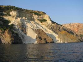 Clay cliffs and with blue sky and water. The precipitous shore by the river. Blue sky with huge sand cliffs and cliffs. photo