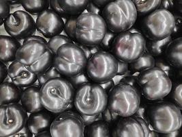 A bunch of fresh and healthy black plums photo