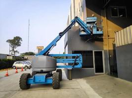 Manlift crane with platform lifting to the roof top of a building photo