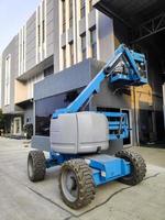 Manlift crane with platform lifting to the roof top of a building photo