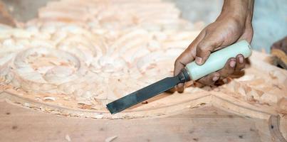 close-up carpenter man's hand treats the tree, cuts the shavings. Copy space. woody curl. Manual processing of wood in the workshop. joiner woodworker in process. photo