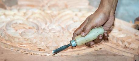 close-up carpenter man's hand treats the tree, cuts the shavings. Copy space. woody curl. Manual processing of wood in the workshop. joiner woodworker in process. photo