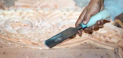 close-up carpenter man's hand treats the tree, cuts the shavings. Copy space. woody curl. Manual processing of wood in the workshop. joiner woodworker in process. photo