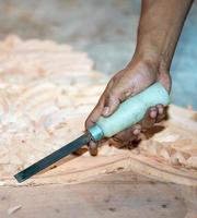 close-up carpenter man's hand treats the tree, cuts the shavings. Copy space. woody curl. Manual processing of wood in the workshop. joiner woodworker in process. photo